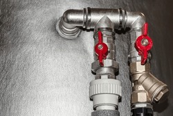 Valves on Pipes of Water Heating System of House in Winter. Red Water Tap and Pipes connected with Buffer Storage Tank.