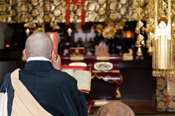 Japanese monk praying at a temple