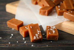 Salted caramel candies on wooden background, close up and copy space