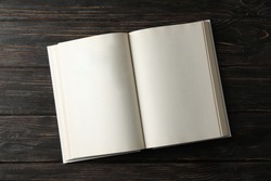 Opened empty book on wooden background, space for text
