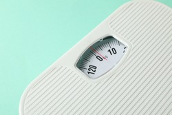 White scales on mint background. Weight loss concept