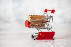 Parcel Boxes with a flag of China in a shopping cart. Duty, customs fee, customs tax, customs payment, custom duties. International Trade in Goods.