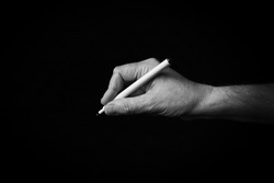 Dramatic black and white image of Writing Hand emoji isolated on black background