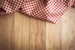 the checkered tablecloth on wooden background. Use for background.