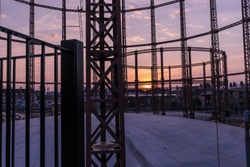 Silhouette of an empty gas storage cylinders against the dusk sunset sky in  London.
