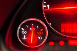 Car engine temperature sensor close up arrows.Lit red sign Overheating or norm,standart of the motor on the dashboard of the car close up.Blurred image.