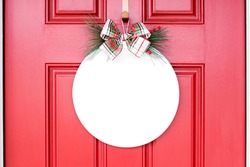 White blank round wood sign on red door with christmas bow hanging on front door, holiday decor mockup