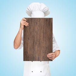 Restaurant chef hiding behind a wooden chopping board for a business lunch menu with prices.