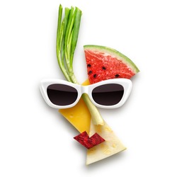 Quirky food concept of female face in sunglasses made of fruits and vegetables, isolated on white.