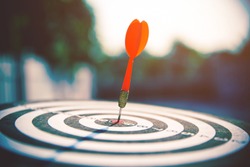 Bullseye or bull's-eye or dart board has dart arrow hitting the center of a shooting target for business targeting and winning concepts.