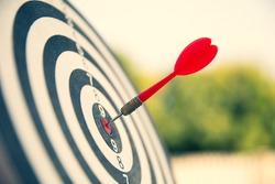 Close-up the bullseye or bulls eye target or dart board has dart arrow throw hitting the center of a shooting for business targeting and aim to winning goals concepts