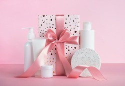 Gift box with cosmetic products on pastel pink background. Body treatment, skincare. Concept of sale, gifts on Valentines day or mother day