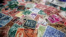 Old postage stamps from various countries as background.