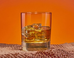 Whiskey on the rocks, with a cool orange gradient background.
