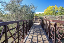 Iron and wood foot bridge located at the Rio Grande Nature Center State Park Albuquerque New Mexico
