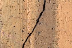Fissure and crack on a concrete wall. Paint color - Mongoose, Tumbleweed, Hue Brown.