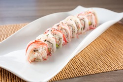 A view of an imitation crab roll sushi plate, in a restaurant or kitchen setting.