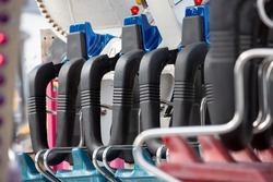 A view of amusement park thrill ride safety harness system seating.