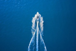 Motor boat in the sea. Aerial view luxury motor boat. Drone view of a boat sailing. Top view of a white boat sailing to the blue sea. Travel - image.
