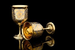 Couple Golden Antique Vintage Brass Shot Glass Gilded on black background. metal Wine Cup goblet with Carving Engraving pattern.