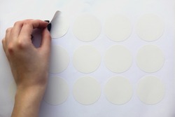 a neat female hand peels off the round white sticker of the plotter trimming.  mockup stickers