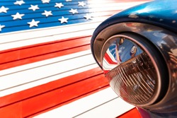 Reflection of American flag in the headlight of a classic car on route 66 america's iconic highway