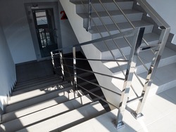 Modern stairs with metal railing in office building. Staircase with gray floor tiles. emergency exit in the shopping or business center .
