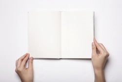 A woman(female) two hands hold a empty(blank) book(note, diary) spread(unfold) isolated white, top view, studio.