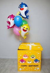 a big yellow box with balloons, a set of balloons baby sharks