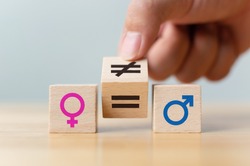 Concepts of gender equality. Hand flip wooden cube with symbol unequal change to equal sign 
