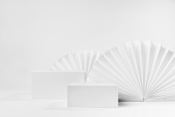 White scene mockup with set of two rectangle box podiums for presentation, show, display of product, goods with light asian ribbed paper fans decoration in simplicity trendy style, front view.