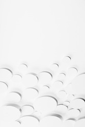 Modern random pattern of white paper ovals different size in shining light with soft light shadows, border, copy space, vertical, top view. Contemporary simple airy gentle stable abstract background.