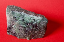 Raw emerald on red.