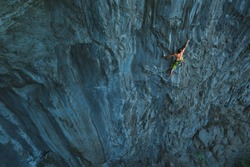 Powerful Rock climber climbing on a big rock wall 