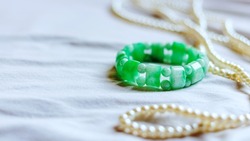 green bangle on white cloth background, green bangle made of jade