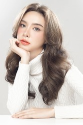 Beautiful young asian woman with clean fresh skin on grey background. Female model wearing white turtleneck Long sleeves Face care, Facial treatment, Cosmetology, beauty and spa, women portrait.
