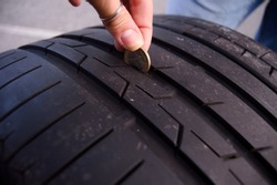 Female Measuring tire depth using a small coin