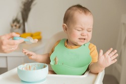 a child of 1 year is naughty at the table, does not want to eat. The concept of feeding a child, the first