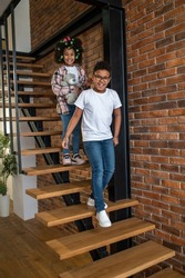 Boy and girl walking down stairs smiling at camera