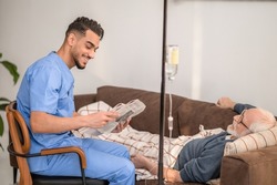 In-home nurse entertaining a patient on the IV drip