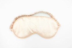 Close up of soft clean orange satin sleeping mask isolated on white background with copy space.