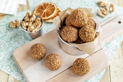 Caramelized walnut balls on wood board and mint background, orange scented healthy nut cookies, homemade simple Christmas treats baking recipes