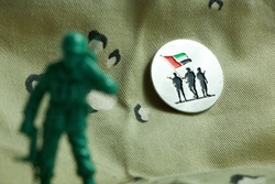 Commemoration Day badge - army toy in front of Commemoration Day badge