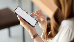 Close up, top view of female with brunette long curly hair using smartphone, scrolling social media feed, smartphone mockup