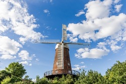 Beautiful scenic Greens Windmill in the Seinton district, Red brick building with four white sails against a blue sky, Nottingham, England, U.K.