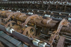 Rusting machinery in abandoned turn of the century silk throwing factory.