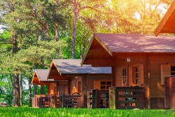 Traditional wooden camping cottages at sunny day in the countryside. Soft focus.