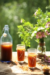 Russian kvass made from rye bread in a bottle and glasses against the background of an open window. Fermented drink. Close up. Summer drink
