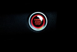 Red push engine start and stop Button noticeable on black background. New technology of car. transportation and sefety concept.