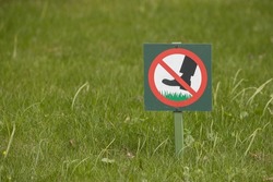 A sign in the park forbidding walking on lawns with grass